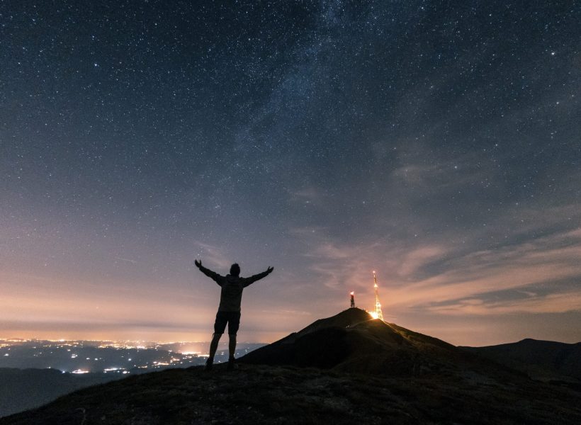 Italy, Monte Nerone, silhouette of a man looking at night sky with stars and milky way